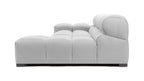 Light gray tufted sectional couch in a spacious living room, offering plush seating and sophisticated style.